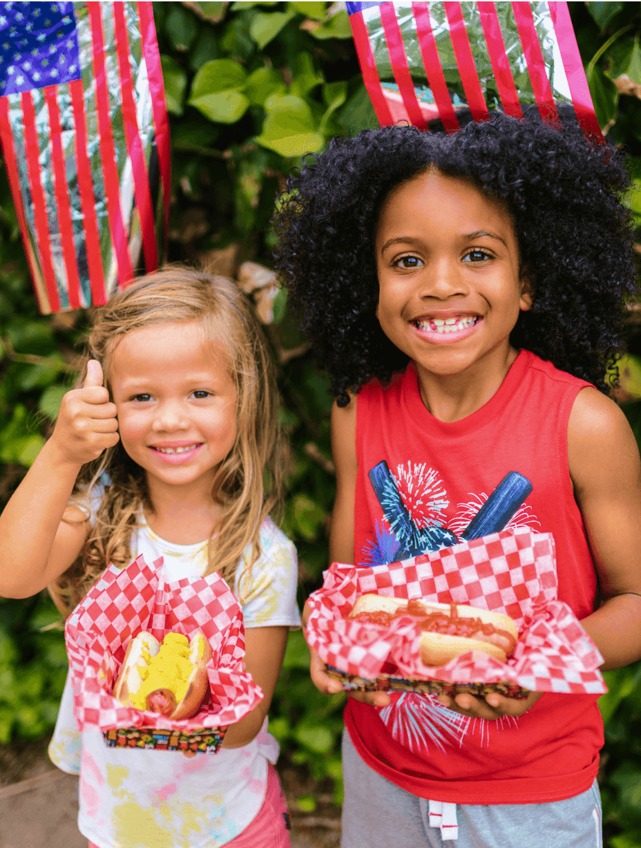 Two children holding food on the Fourth of July