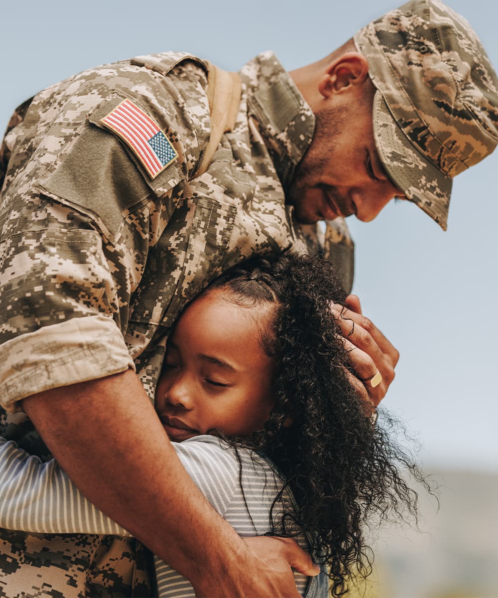 United States Army member hugging his child
